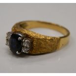 An unmarked gold diamond and sapphire ring. Ring size N/O (5.