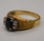 An unmarked gold diamond and sapphire ring. Ring size N/O (5.