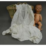 An early 20th century doll and two lace gowns. Doll approximately 49 cm high.