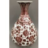 A Chinese porcelain baluster vase, decorated in iron red with lotus strapwork. 31 cm high.