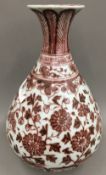 A Chinese porcelain baluster vase, decorated in iron red with lotus strapwork. 31 cm high.