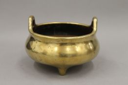 A finely cast 19th century Chinese two handled bronze incense burner on three short feet,