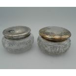 Two silver topped powder jars. 11 cm wide.
