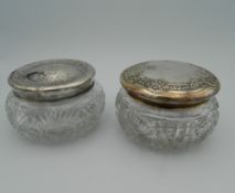 Two silver topped powder jars. 11 cm wide.