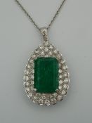 An 18 ct white gold diamond and emerald pendant on a chain. The pendant 4 cm high (15.