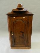 A Georgian oak hanging corner cupboard. 117 cm high.