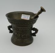 A 17th century bronze pestle and mortar. 11 cm high.