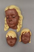 Three West German pottery wall masks. The largest 20 cm high.