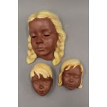 Three West German pottery wall masks. The largest 20 cm high.