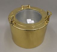 A brass ice bucket formed as a port hole. 19 cm high.