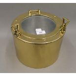 A brass ice bucket formed as a port hole. 19 cm high.