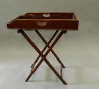 A Victorian mahogany butlers tray on stand. 65 cm long.