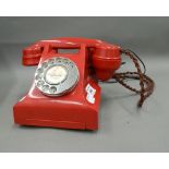 A vintage red telephone. 23 cm wide.