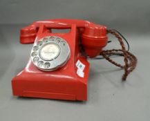 A vintage red telephone. 23 cm wide.