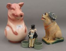 A jug formed as a pig and a piggy bank, together with a small pot mounted with a pig. The former 24.