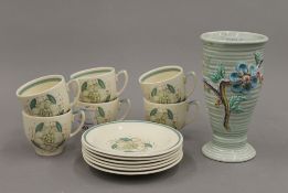 A small Clarice Cliff vase and a set of six Susie Cooper coffee cups and saucers.