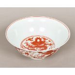 A Chinese porcelain bowl, decorated with dragons chasing flaming pearls amongst stylised clouds,