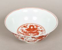 A Chinese porcelain bowl, decorated with dragons chasing flaming pearls amongst stylised clouds,