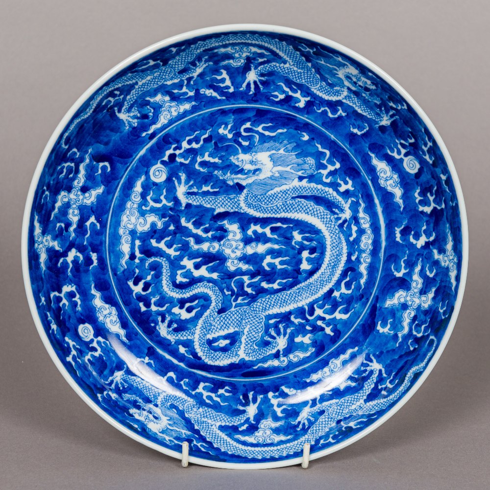 A Chinese blue and white porcelain dish, decorated with dragons chasing flaming pearls,