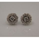 A pair of 18 ct white gold diamond halo earrings.