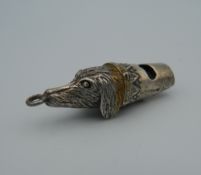 A silver whistle in the form of a dog's head. 4.5 cm long.