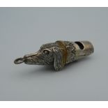 A silver whistle in the form of a dog's head. 4.5 cm long.