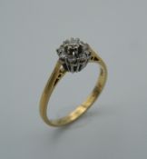 An 18 ct gold diamond flowerhead ring. Ring size O (2.