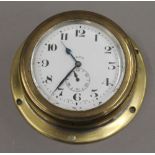 A 1930s brass dashboard clock. 10.5 cm diameter.