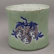 A Chinese celadon ground porcelain brush pot decorated with fruit. 16.5 cm high.