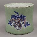 A Chinese celadon ground porcelain brush pot decorated with fruit. 16.5 cm high.