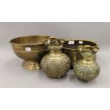 A footed brass bowl with overall engraving,