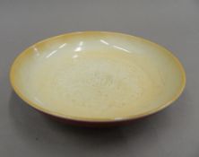 A Chinese porcelain red glazed dish. 18.5 cm diameter.