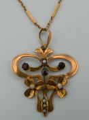 An Edwardian 9 ct gold garnet and seed pearl set pendant on a 9 ct gold chain -