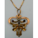 An Edwardian 9 ct gold garnet and seed pearl set pendant on a 9 ct gold chain -