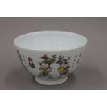 A Chinese porcelain bowl painted in bright enamels with boys in various pursuits,