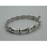 A silver faux bamboo bracelet. 7 cm wide.