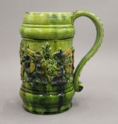 A Castle Hedingham green glazed ale mug with applied moulding depicting animals and wild men,