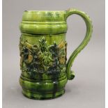 A Castle Hedingham green glazed ale mug with applied moulding depicting animals and wild men,