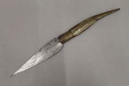 A large 19th century Eastern brass and horn handled folding knife, with engraved blade. 49 cm long.