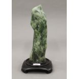 A Chinese green jade scholars rock, fitted to later base. 34 cm high overall.