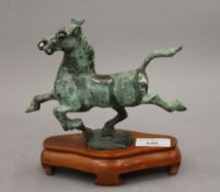 After the Antique, patinated bronze horse on wooden stand. 18 cm long.