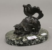 A 19th century Chinese bronze dog-of-fo, mounted on an oval hardstone base. 14 cm high.