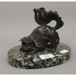 A 19th century Chinese bronze dog-of-fo, mounted on an oval hardstone base. 14 cm high.