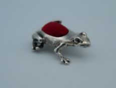 A silver pin cushion in the form of a frog. 1.2 cm long.