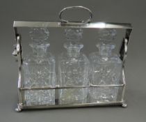 A Victorian three bottled silver plated tantalus, makers mark to base. 36 cm wide.