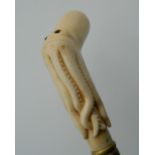 A bone carved walking stick formed as an octopus. 90 cm long.