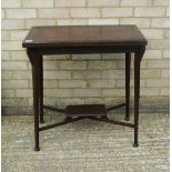 An Edwardian swivel top mahogany games table. 71 cm wide.