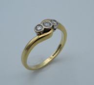 An 18 ct gold three diamond trilogy ring. Ring size L/M (3.