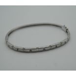 A 9 ct white gold bangle set with diamonds. 6.5 cm wide (9.