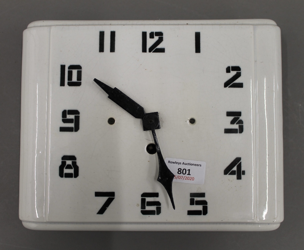 An Art Deco white porcelain wall clock. 24.5 cm wide.